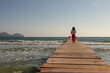 © paulomachado_9 - Young woman in pink pants watching the mediterranean sea on a wooden walkway, Palma de Mallorca