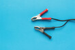 © kvladimirv - Red and black terminals for connecting to the battery on a blue background.