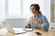 © SHOTPRIME STUDIO - Remote Job Distance communication concept. Smiling cheerful happy cute awesome curly businesswoman speak in online meeting using laptop at home office. Copy space for ad