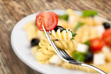 Poster - Noodles with parmesan in cream sauce in a white plate on the kitchen table. Traditional Italian pasta on a light culinary background.