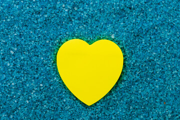 Paper sticker in the shape of a heart on the background of sea aromatic bath salts. The concept of romantic enjoyment