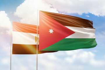 Sunny blue sky and flags of jordan and egypt