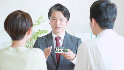 Canvas Print - 家の模型を使って説明する日本人男性とカップル