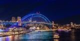 Colourful Light show at night on Sydney Harbour NSW Australia. The bridge illuminated with lasers and neon coloured lights 