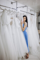 Wall Mural - Woman choosing wedding dress in shop