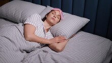 Woman In A Pink Eye Mask Lies Under A Blanket In A Bed And Suffers From Insomnia