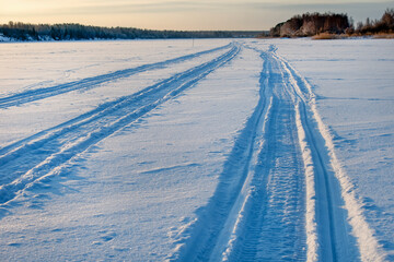 Wall Mural - Traces of vehicles and people on the frozen and snow-covered Volga River