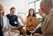 © Halfpoint - Excited elderly people attending group therapy session at nursing house, positive senior man and woman sitting in circle, having conversation with psychologist