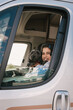 © Amparo Garcia - Happy girl with her black dog looking out of the caravan window