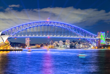 Wall Mural - Colourful Light show at night on Sydney Harbour NSW Australia. The bridge illuminated with lasers and neon coloured lights 