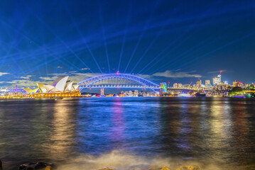 Wall Mural - Colourful Light show at night on Sydney Harbour NSW Australia. The bridge illuminated with lasers and neon coloured lights 