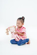 © Akmalism Photography - Portrait Little girl Attractive woman holds her favorite toy or pink baby doll. Cute girl looks so happy. Lovely young lady wears with isolated, white background