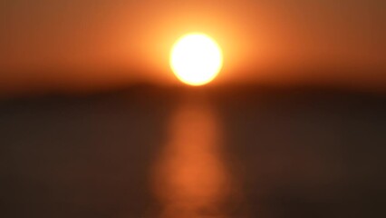 Wall Mural - blurry defocused sunset marine landscape. 4k video bokeh of orange defocused sun circle isolated on 