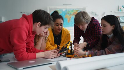 Sticker - Group of students building and programming electric toys and robots at robotics classroom