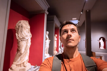 Wall Mural - Man taking selfie photo in the hall with Greek antique statues of women and goddesses in the interiors of the Archaeological Museum in Antalya