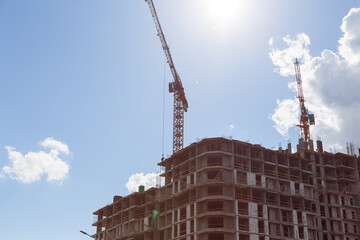 Crane and building under construction against blue sky