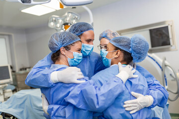 Canvas Print - Partial view of hard-working male and female hospital team in full protective wear standing together in group embrace