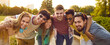 Leinwandbild Motiv Group of happy people spending their weekend in nature. Portrait of joyful multiracial friends having good time relaxing together in summer park. Friends hugging and smiling at camera. Web banner.