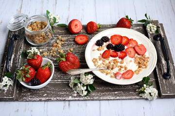 Wall Mural - Healthy and nutritious breakfast. Muesli with strawberries and blackberries on a wooden tray