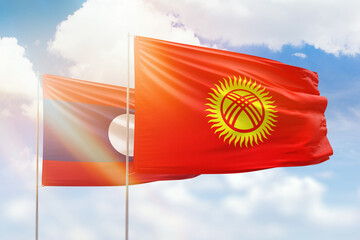 Sunny blue sky and flags of kyrgyzstan and laos