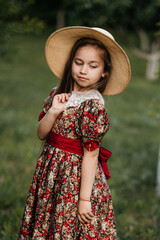 Wall Mural - Beautiful girl in a vintage dress 7-8 years old posing in the garden. Beautiful spring garden. The concept of a happy childhood, peace and happiness.