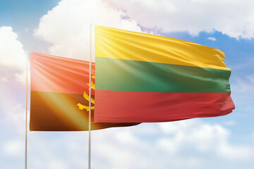 Sunny blue sky and flags of lithuania and angola