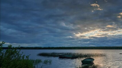 Wall Mural - Sunset. Strong wind carries clouds over the rive