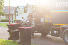 Garbage Truck Picking Up Bins From Curb Side In Suburban Area