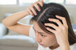 © KMPZZZ - Damaged Hair, face serious asian young woman worry looking at scalp in mirror, hand in break into front hair loss, thin problem symptom at home. Health care shampoo beauty, isolated on background.