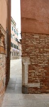 Narrow Street Between The Walls Of Two Italian Houses In The Island Of Venice