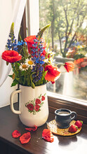 Bouquet Of Wild Summer Flowers On The Window. Poppies, Cornflowers, Daisies And Lupines In A Rustic Pot. Cup Of Coffee And Strawberries. Side View.