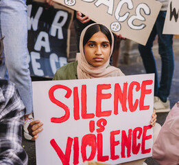 Wall Mural - Muslim girl holding an anti-violence poster