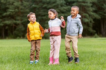 Wall Mural - childhood, leisure and people concept - group of happy children playing and jumping at park