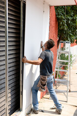 Worker placing drywall sheets on metal structure