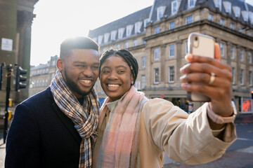 Wall Mural - Couple Smiling and Taking Selfie With Mobile Phone