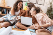 © BalanceFormCreative - Group of female student doing a homework . They're sitting on the floor in their living room.