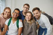 © Studio Romantic - Diverse team of five happy, cheerful college or university students, classmates and friends. Indoor group portrait of multiracial young people with backpacks looking at the camera and smiling