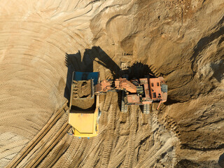 Canvas Print - Mining excavator in an open pit during sand mining. Excavator at the development of a sand pit. Earth Moving Machine load sand in mining truck.Earthmover on sand mining. Heavy machinery in industry..