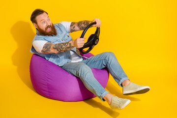 Photo of cool funky man wear jeans waistcoat sitting beanbag playing video game empty space isolated yellow color background