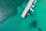 Fototapeta Na drzwi - Port, pier, dock with boats, cruise ship in blue, turquoise sea water. Summer vacations and travel concept. Marina. Aerial, drone view