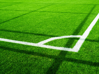 Corner of green football field of artificial grass. White line on the soccer field.