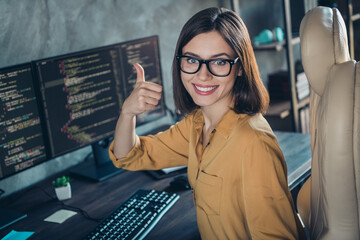 Sticker - Portrait of beautiful cheerful girl web designer developing web startup showing thumbup done at workplace workstation indoors