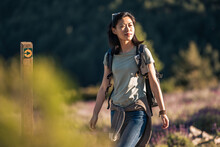 Traveling Asian Woman With Backpack Walking In Nature