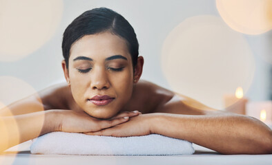 Nothing can spoil her mood. Shot of a relaxed an cheerful young woman getting a massage indoors at a spa.