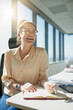 © Adene Sanchez/peopleimages.com - Working with the sun on my back. Shot of a cheerful young businesswoman writing in her notebook while being seated at her desk inside the office during the day.