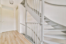 Gray Spiral Staircase Connecting Levels Of Modern House With Wooden Floor And White Walls