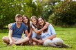 © Nikish Hiraman/peopleimages.com - I love you guys so much. Portrait of a cheerful young family seated in a park together outside during the day.