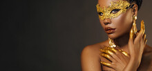 Portrait Sexy African Woman Face Close Up In Golden Venetian Carnival Mask. Girl Fashion Model Perfect Skin, Golden Evening Holiday Makeup, Glitter Diamond Stones Lip Gloss, Hands In Gold Liquid Paint