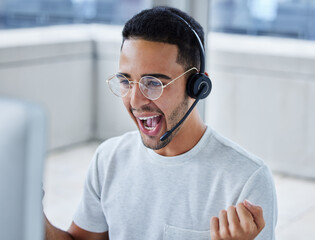 Achieved my daily target my leaps and bounds. Shot of a young businessman working in a call center office helping a client.