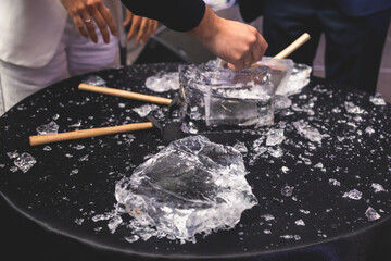 Wall Mural - Process of breaking the ice with hammer and ice pick, group of people smashing shattered ice cube, team work success concept, concept of starting event, conversation